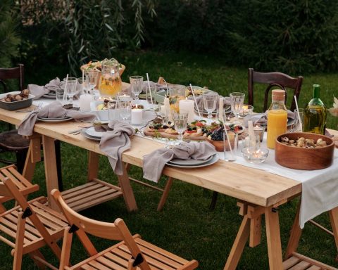 food on brown wooden table with chairs and plates