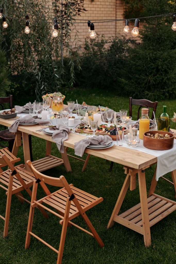 food on brown wooden table with chairs and plates