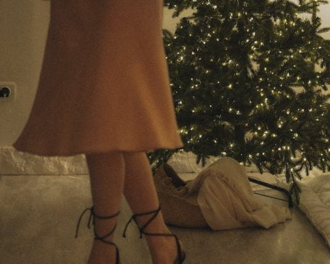 low section of woman standing in front of christmas tree