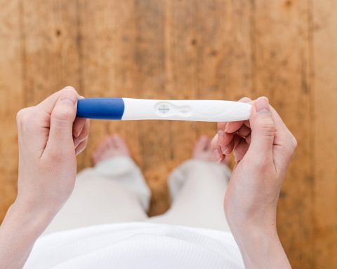 crop woman with pregnancy test