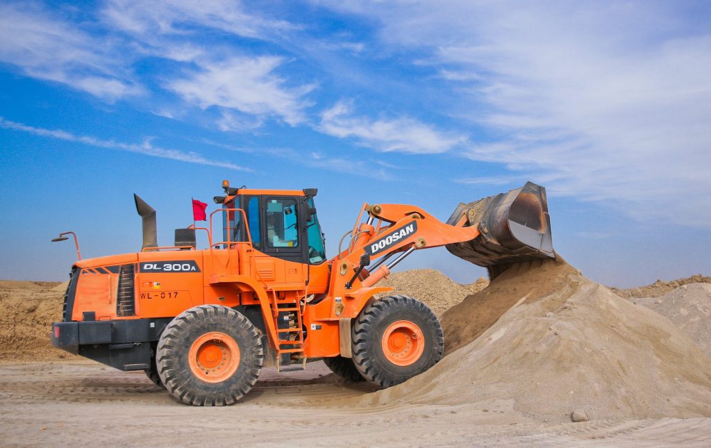 orange excavator on brown hill