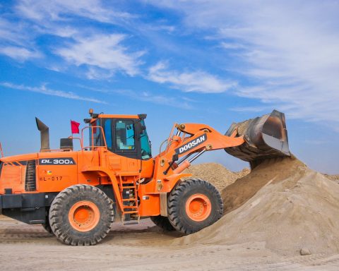 orange excavator on brown hill