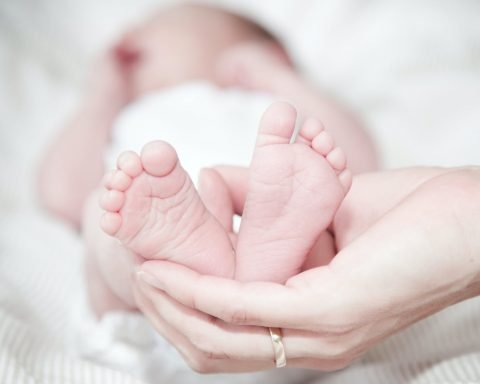 close up of hands holding baby feet