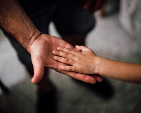 selective focus photography of child s hand