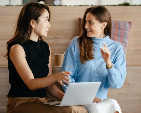 multiracial businesswomen with laptop talking about work