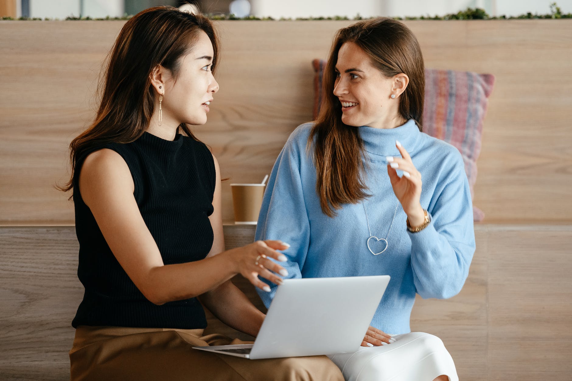 multiracial businesswomen with laptop talking about work