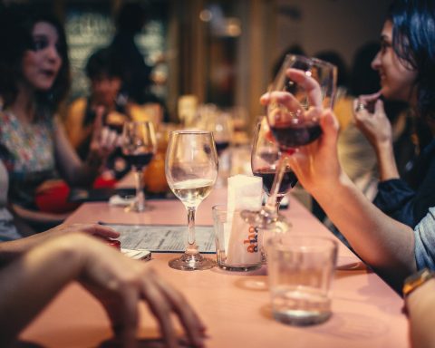 people drinking liquor and talking on dining table close up photo