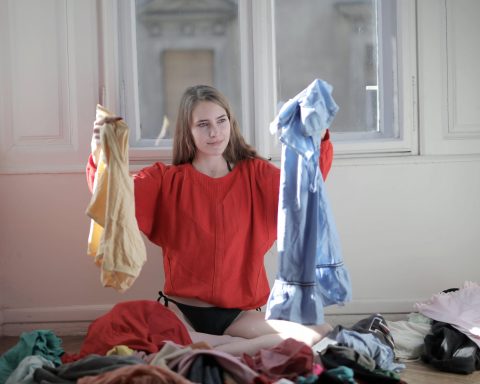 woman in red long sleeve shirt holding her clothes