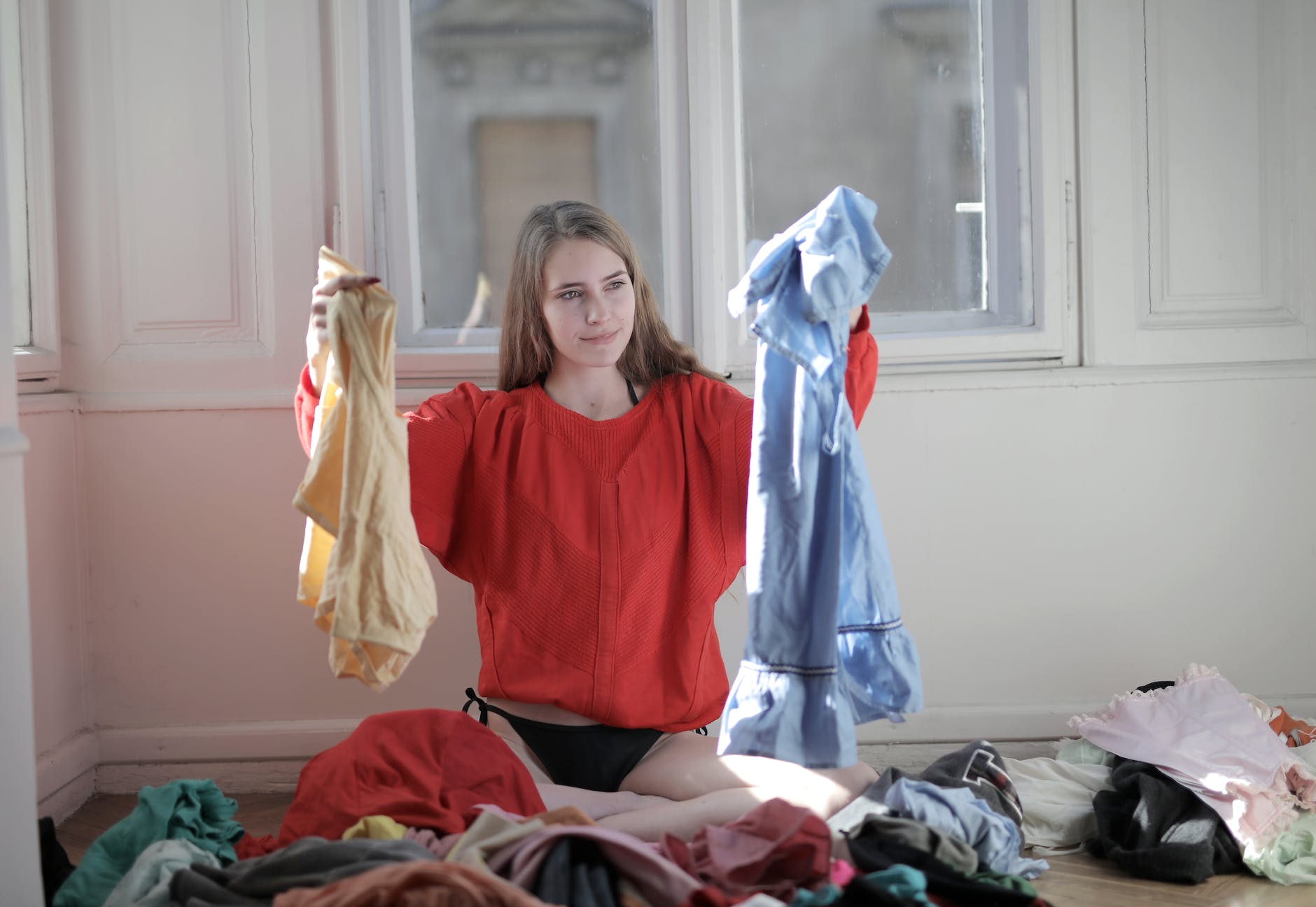 woman in red long sleeve shirt holding her clothes