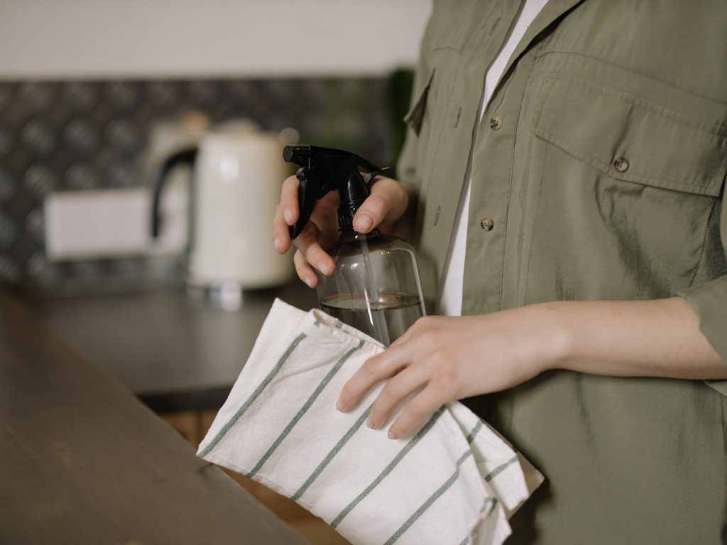 person in green button up shirt holding clear drinking glass