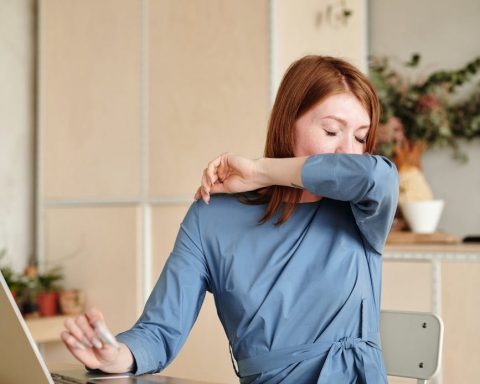 a sick woman covering her mouth